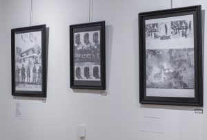 three black frames hanging on a wall for "The Riot Show" at The Gallery at The Kranzberg